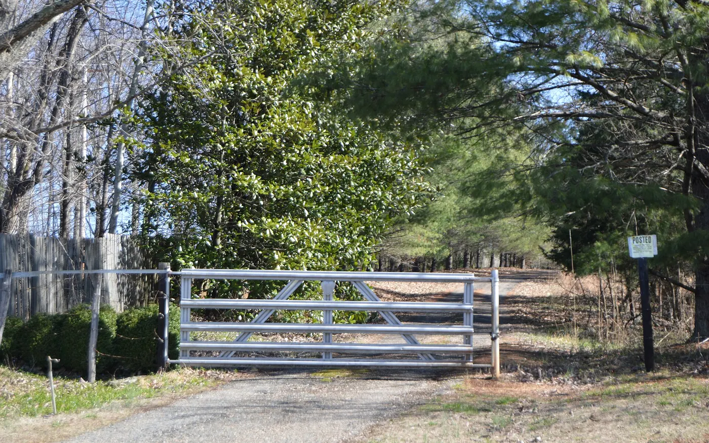 Steel driveway gate between stone pillars
